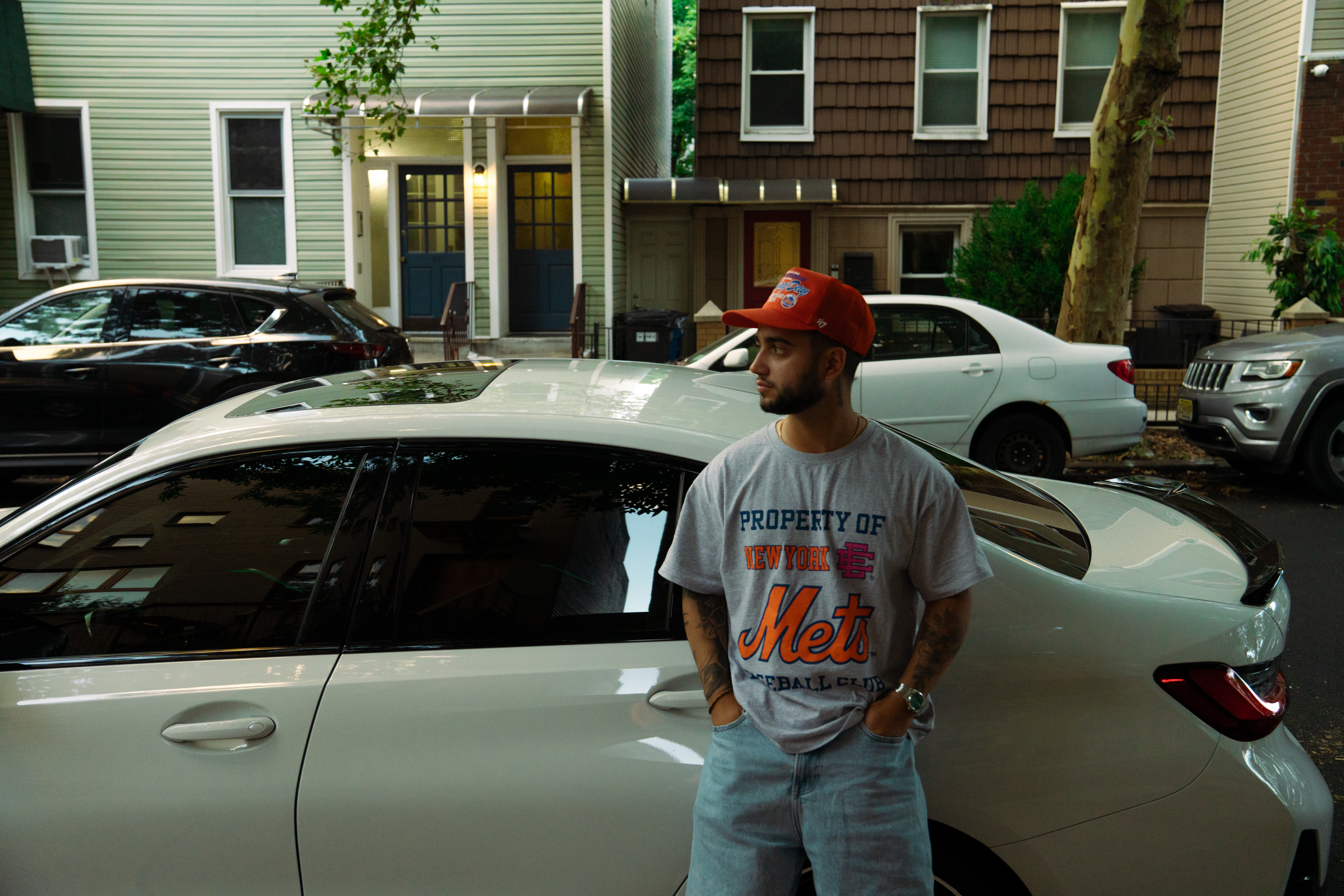 Jose wearing a New York Mets shirt and standing beside a car